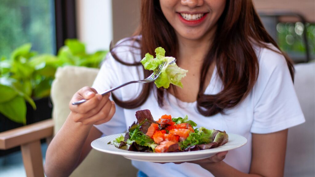 Femme qui savoure son repas avec plaisir, symbole de réconciliation avec la nourriture après un trouble du comportement alimentaire.