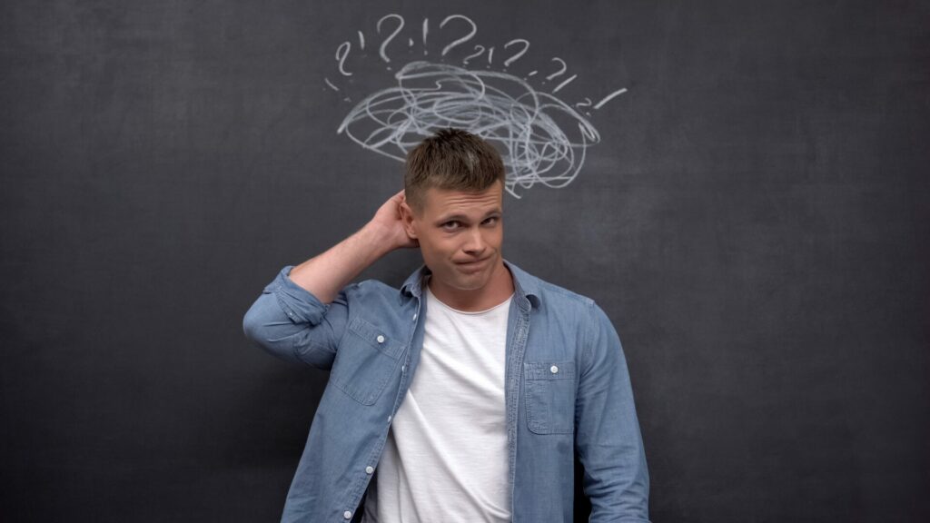 Homme pensif entouré de points d’interrogation symbolisant les doutes et le manque lors de l’arrêt du tabac.