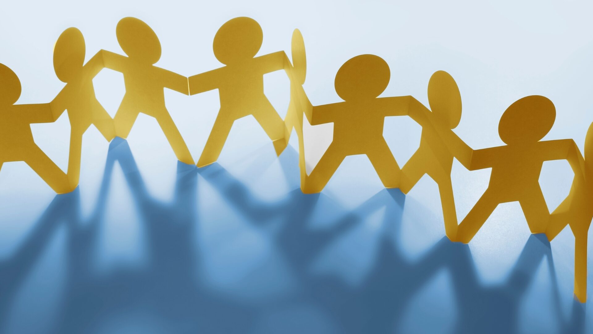 Bonhommes de papier se tenant par la main en farandole, symbolisant la force du collectif et l’accompagnement du réseau LaserAddict auprès de chaque centre.